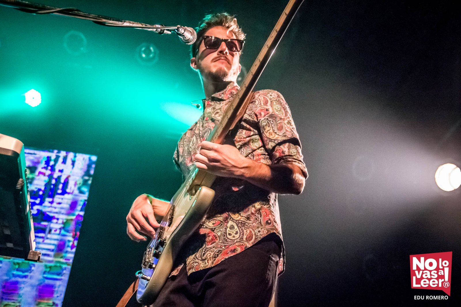 Leandro Juarez playing bass under green stage light